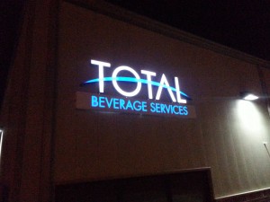 A nighttime picture of Total Beverage logo sign installed.