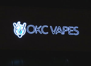 Nighttime picture of illuminated channel letter sign for OKC Vapes in Norman, OK.