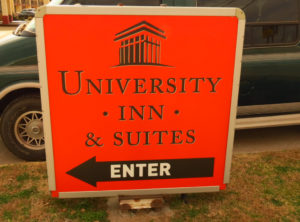 Close up picture of orange directional sign at a hotel entrance.