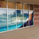 An angled view of 5 store front windows with vinyl graphics.